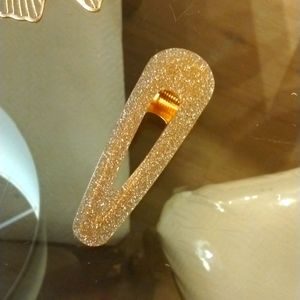 A sparkling golden hair clip.